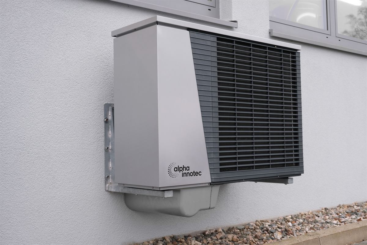 Wall-mounted residential heat pump outdoor unit on a rendered white wall