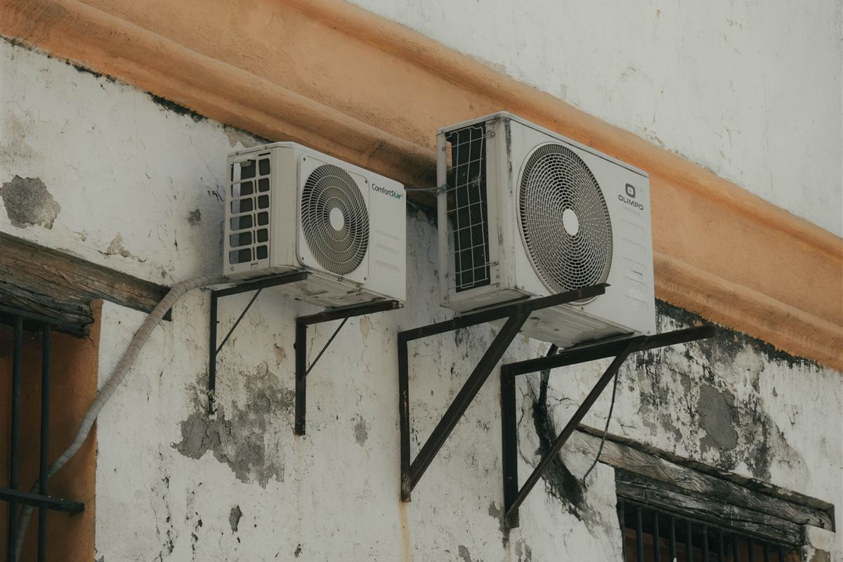 Outdoor heat pump units on a weathered exterior wall